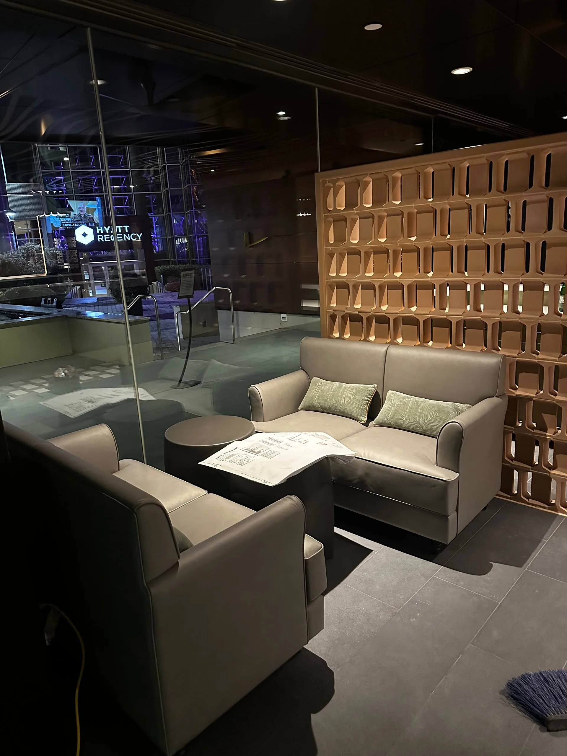 Lounge seating beside an open geometric room divider at the entrance to the hotel lobby.